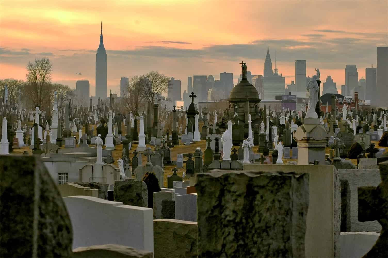 Calvary Cemetery, Queens, NY. The upright monuments in the graveyard are echoed by the uprights of the skyscrapers of Manhattan in the background.