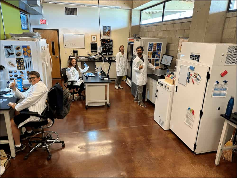 Scientists welcome you to the SeedLab with a cheery thumbs up.