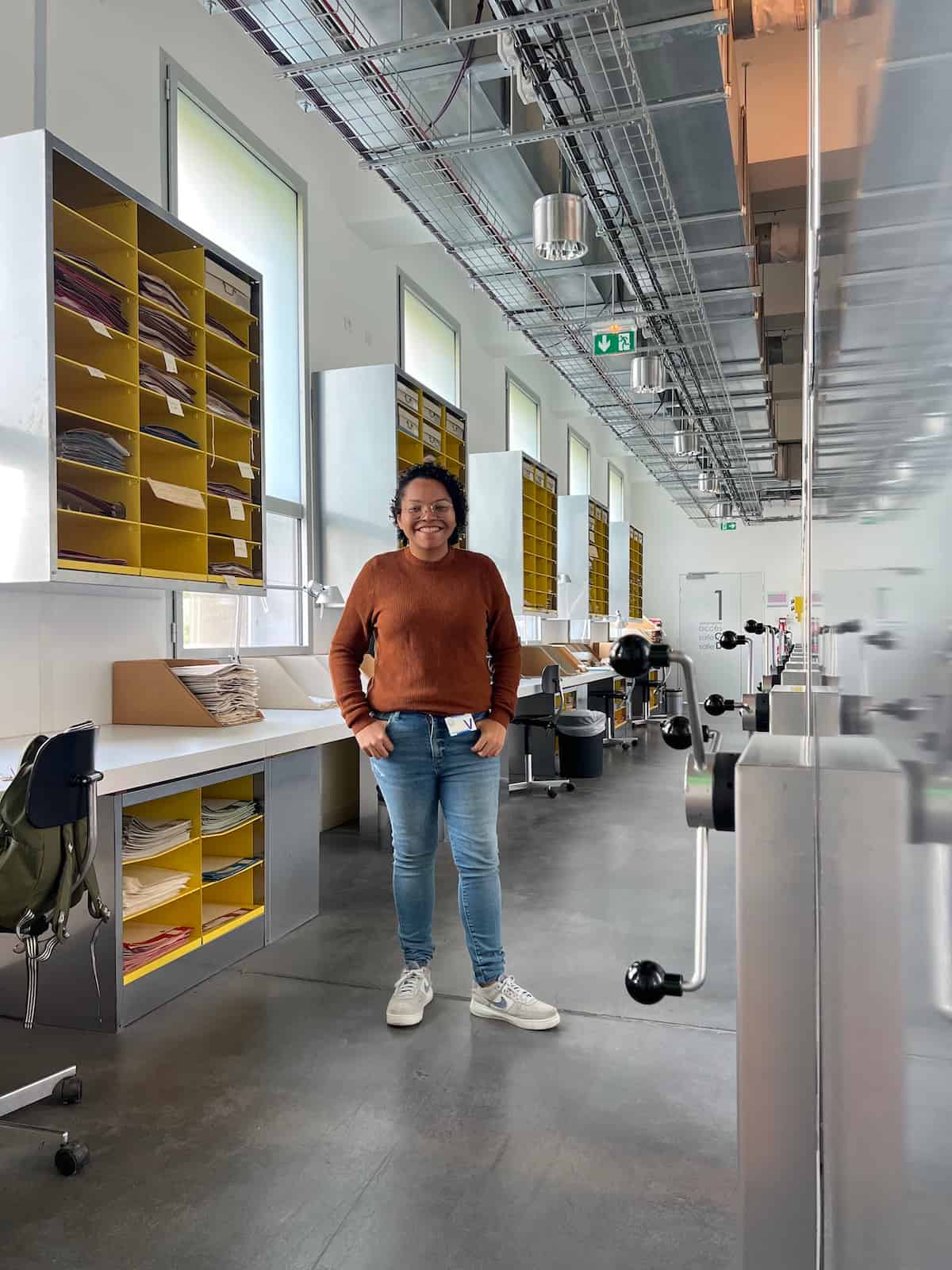 Gláucia Silva standing smiling in a herbarium.