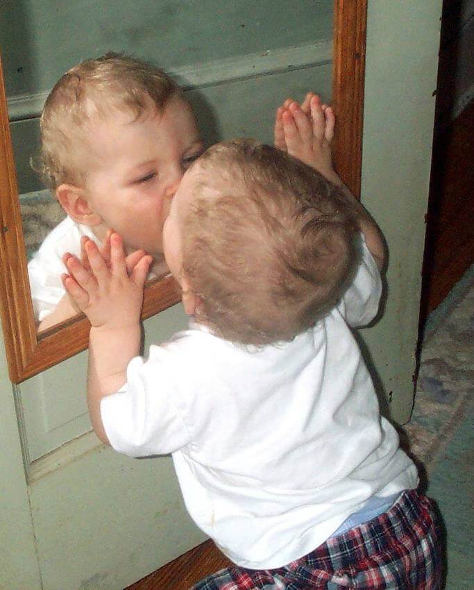 Baby kissing mirror image