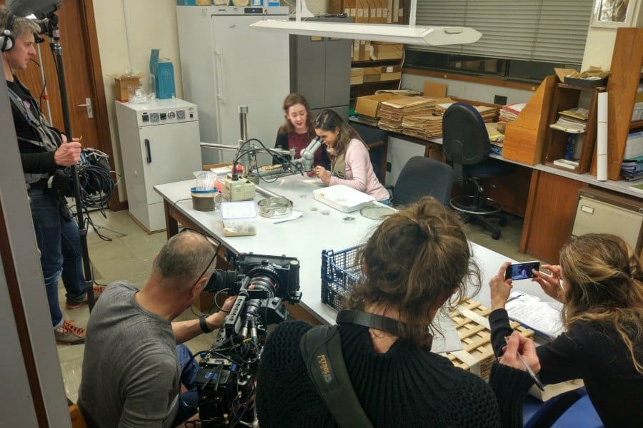 Many people in a tiny room while filming in the Herbarium