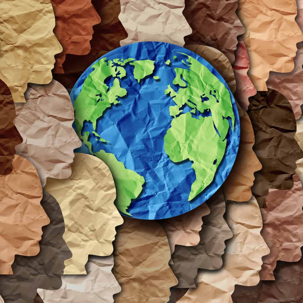 A series of paper cut outs of heads in various shades, signifying diversity. Among them is the planet Earth.