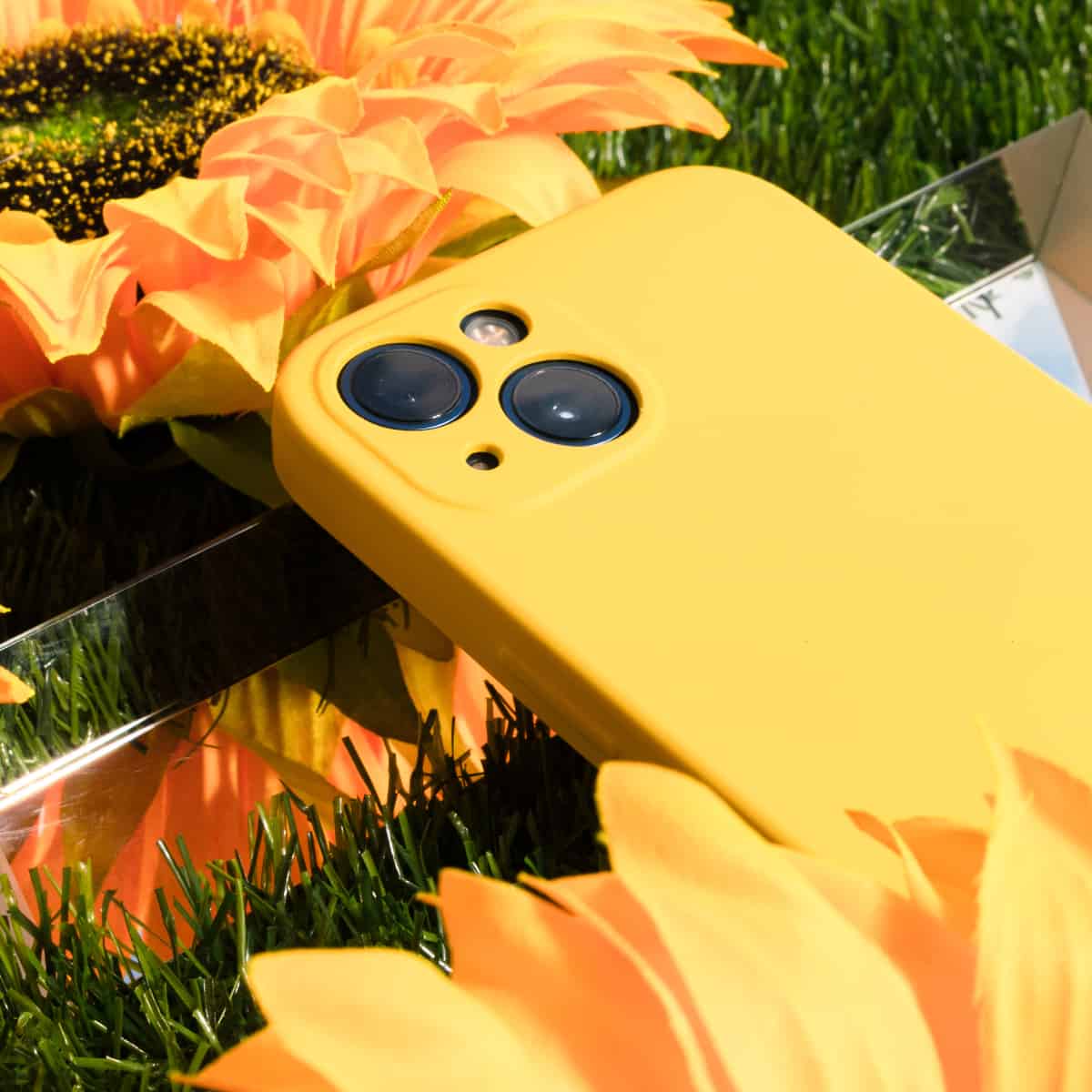 A smartphone and some flowers on grass.