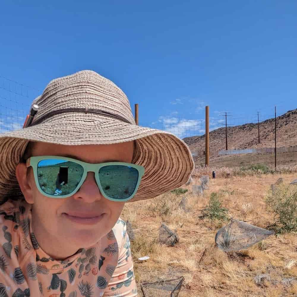 Karolina Heyduk taking a selfie during desert fieldwork, wearing a sun hat and sunglasses with a cactus-patterned shirt.